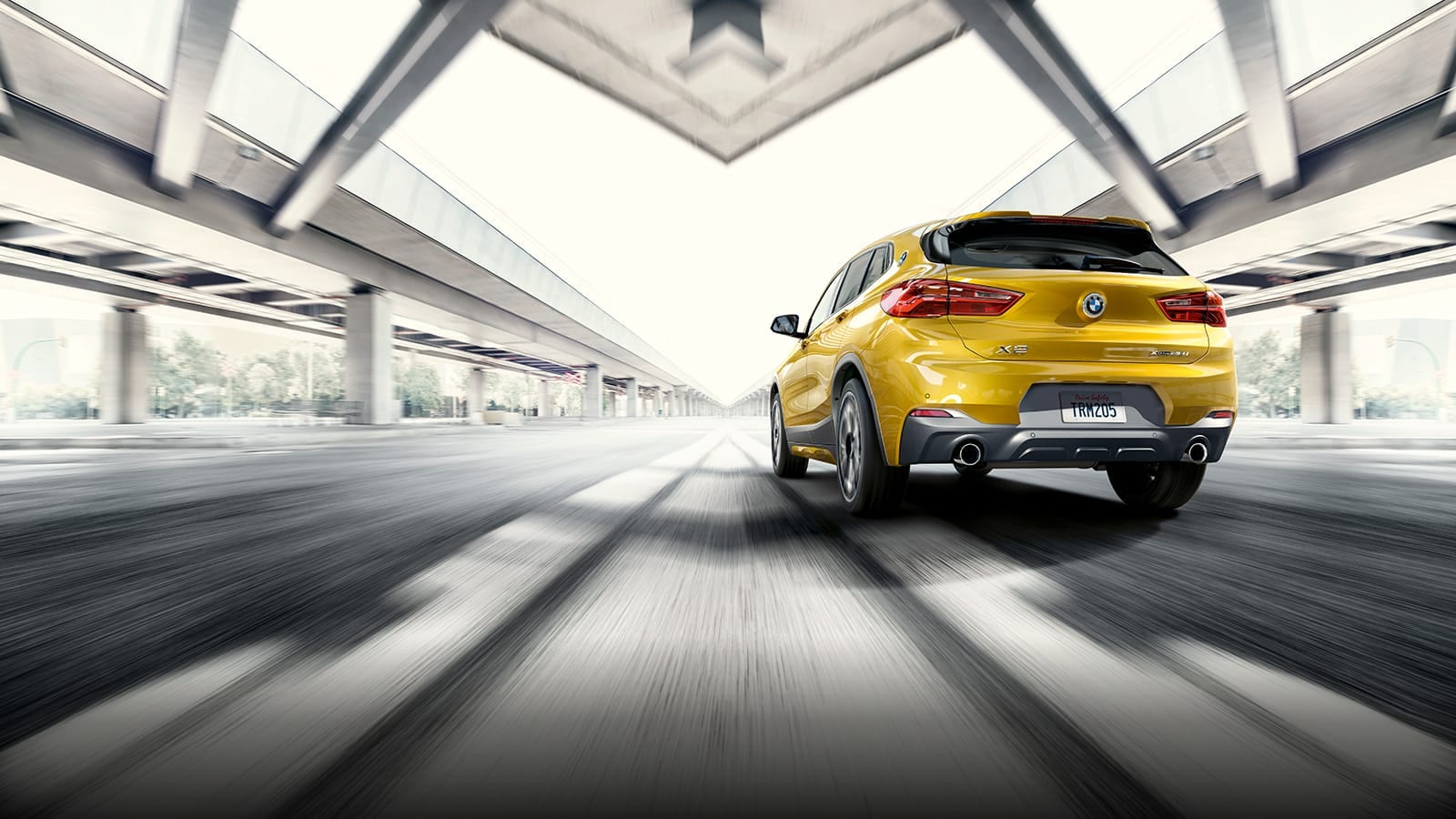 rear view of yellow bmw x2 in motion 