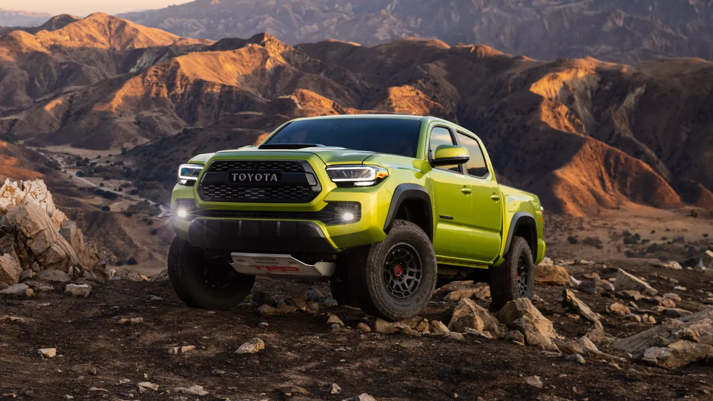 green TOYOTA TACOMA fron angular view on the top of the mountain
