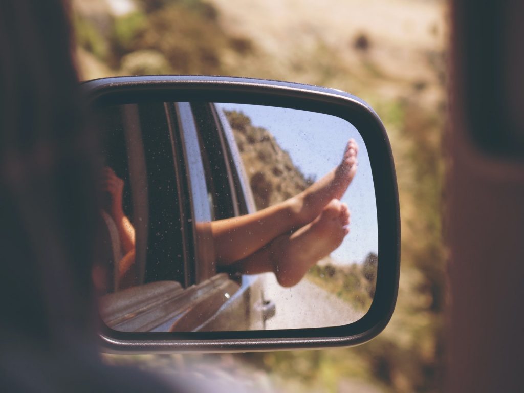 rearview mirror reflecting a person's feet