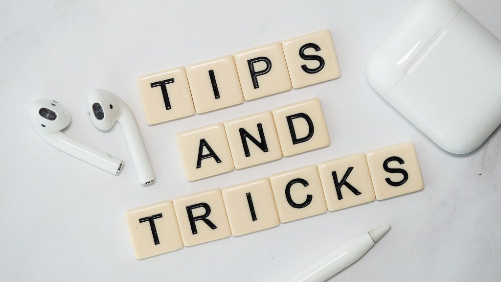 tiles making a phrase "tips and tricks" with a pair of headphones and a pen
