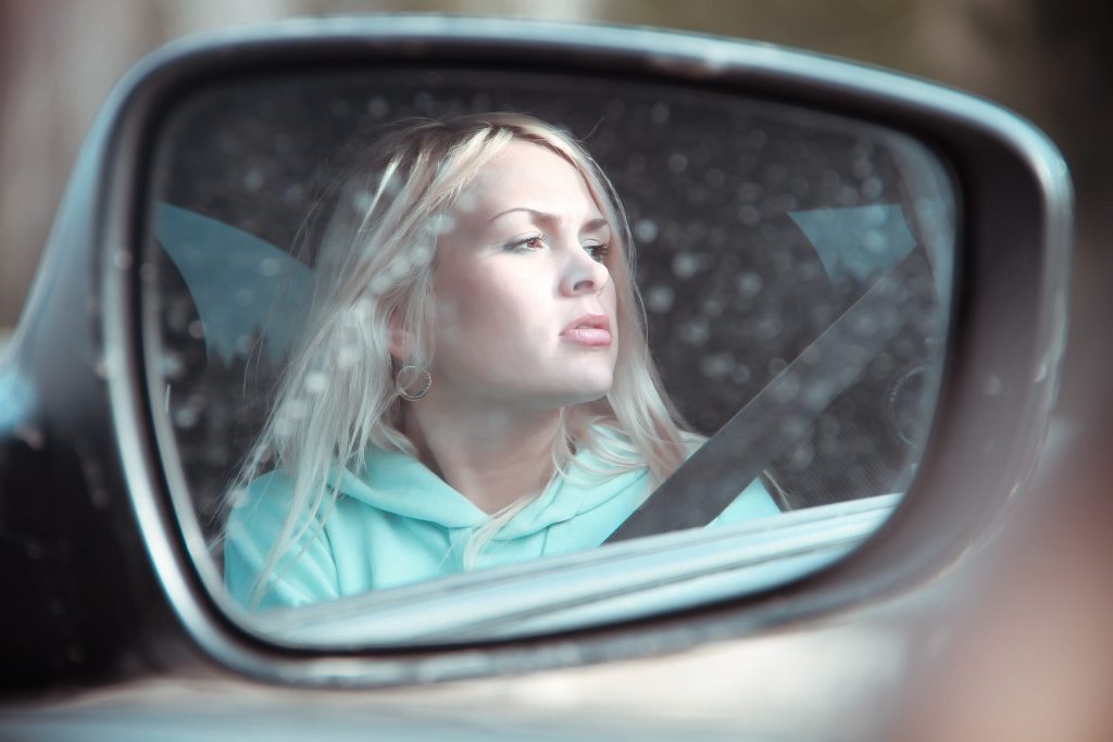 rearview mirror reflecting a blond girl