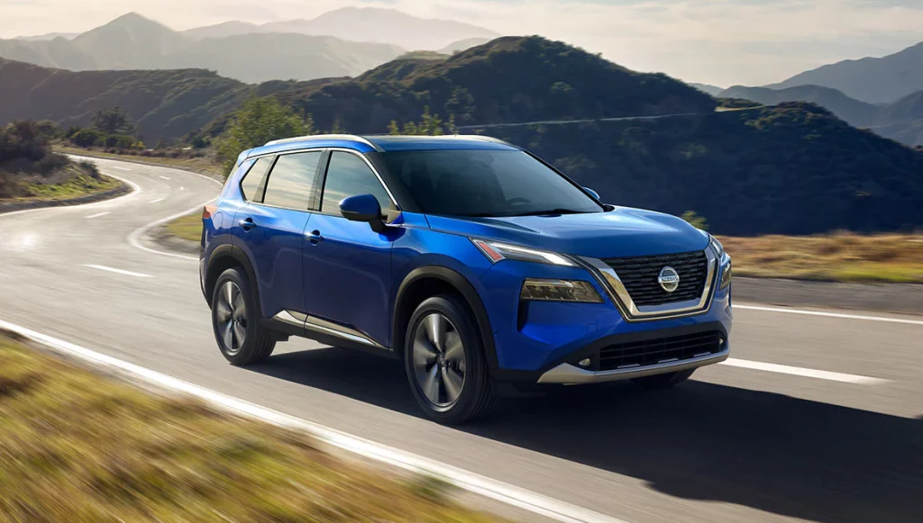 blue 2021 nissan rogue with a highway in the mountains on the background