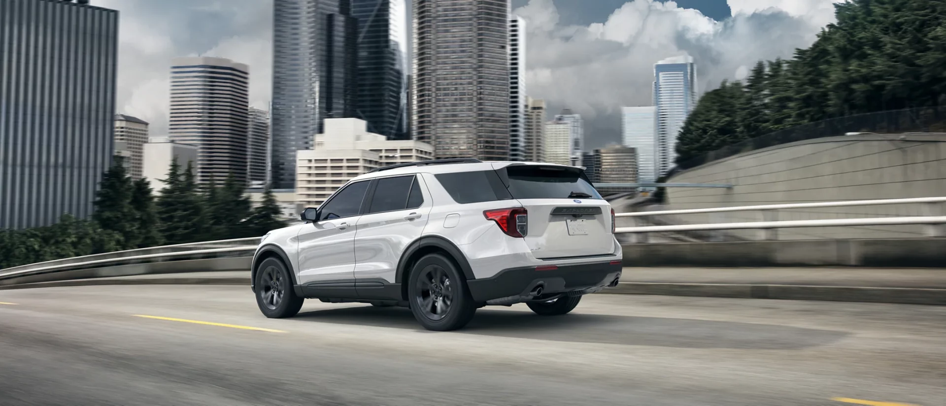 white 2021 ford explorer driving in the city