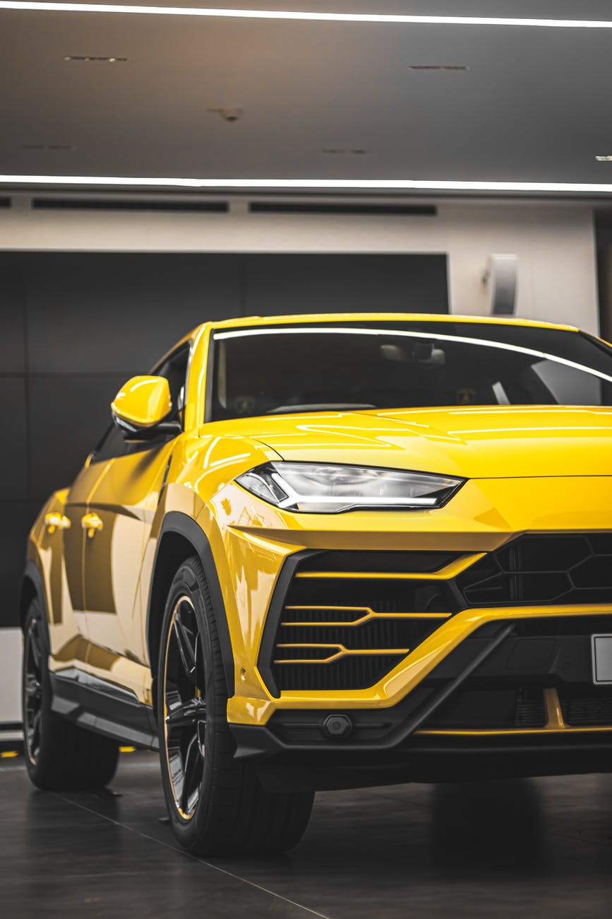 the right exterior side of the yellow Lamborghini Urus 2021 which stands on the black floor 