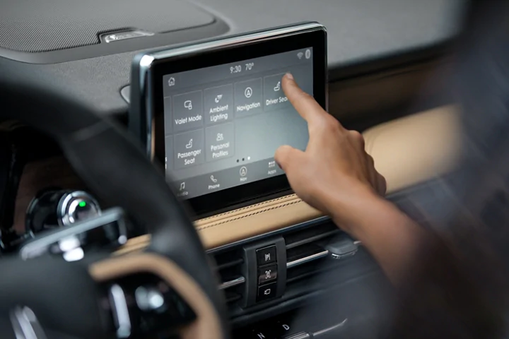 The person touches the small touchscreen in the Lincoln MKC