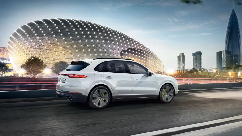 white 2021 porsche cayenne in the motion on the background of the monument