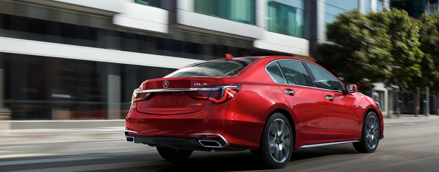 red Acura RLX rear angular view in the motion near the building